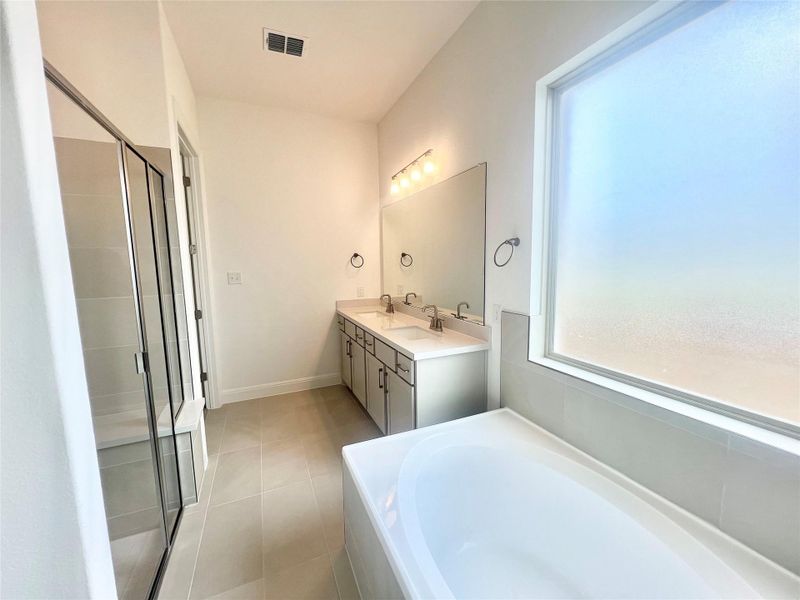 Bathroom featuring a bath, double vanity, a stall shower, and tile patterned flooring Bathroom featuring a bath, double vanity, a stall shower, and tile patterned flooring