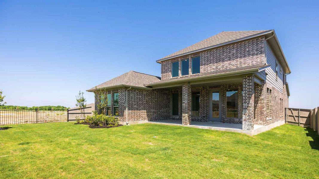 Rear view of property featuring a patio, roof with shingles, brick siding, a fenced backyard, and a lawn Rear view of property featuring a patio, roof with shingles, brick siding, a fenced backyard, and a lawn