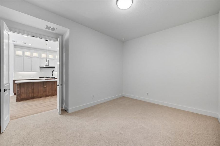 Empty room with light colored carpet and recessed lighting Empty room with light colored carpet and recessed lighting