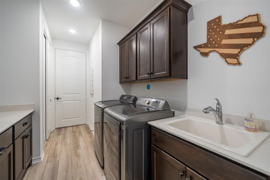 The functional utility room is accessed through the hallway and second primary closet and has a sink, folding counter, cabinetry, closet, and is easy to walk-through.