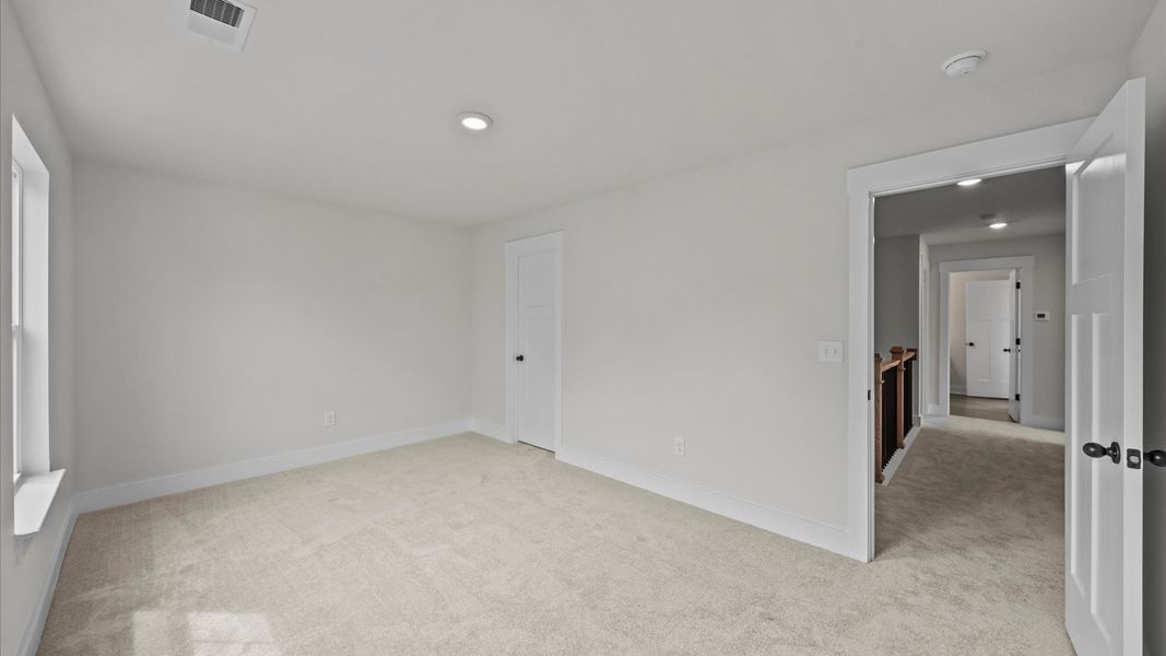 First-class secondary bedroom with comfortable carpeted flooring and generous closet space