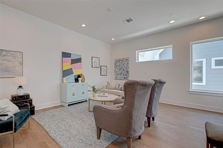 Bright and welcoming, this living space features high ceilings, recessed lighting, and wide wood flooring. The sleek layout and natural light create the perfect backdrop for relaxing or entertaining.