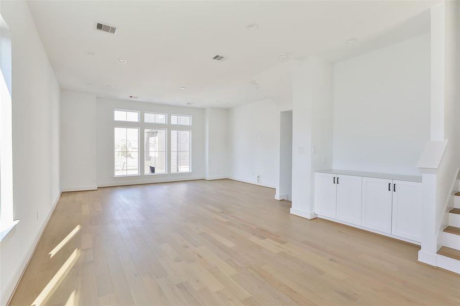 Picture yourself dining with friends and family in this spacious, open second-floor living area. To the right, a dry bar with ample storage is perfect for your decor, dishes, and more.