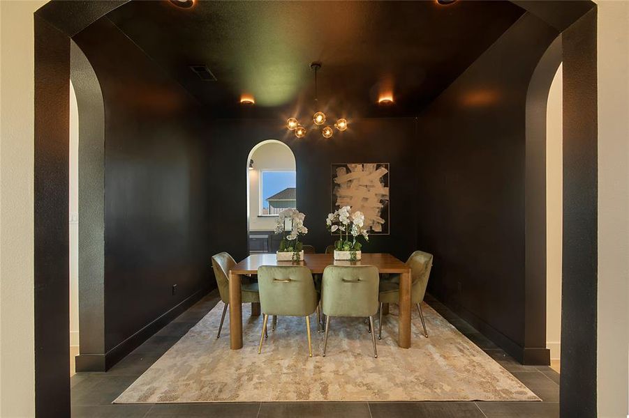 Dining area featuring arched walkways, tile patterned floors, and a chandelier Dining area featuring arched walkways, tile patterned floors, and a chandelier