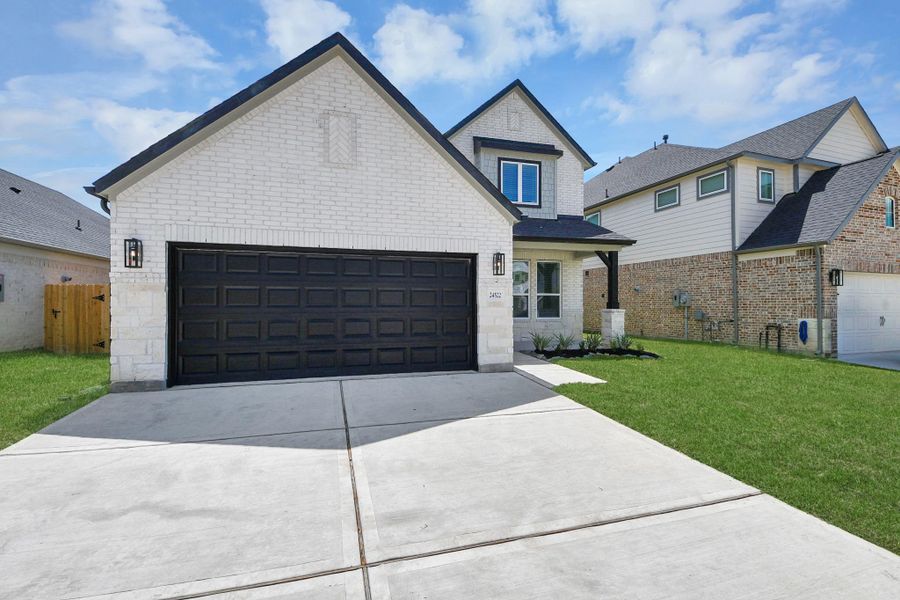 Meticulously maintained yard and lush landscape, paired with a premium elevation featuring captivating brick accents. Modern coach lights add a touch of contemporary elegance to the exterior.