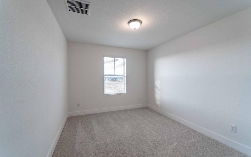 Empty room featuring light carpet and baseboards