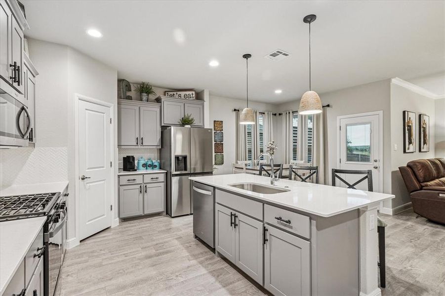 Kitchen featuring gray cabinetry, stainless steel appliances, a sink, decorative backsplash, and recessed lighting Kitchen featuring gray cabinetry, stainless steel appliances, a sink, decorative backsplash, and recessed lighting