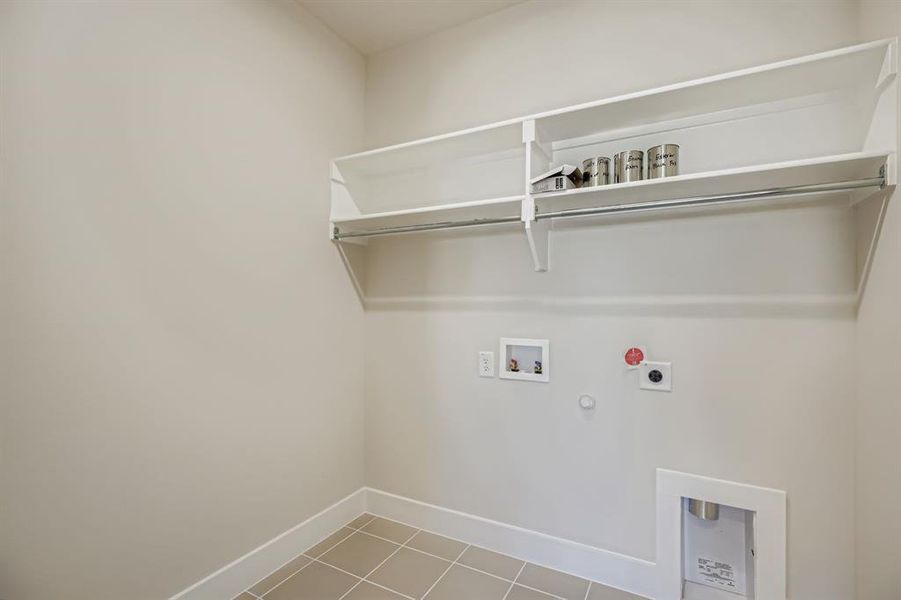 Washroom with hookup for a gas dryer, light tile patterned floors, washer hookup, and hookup for an electric dryer