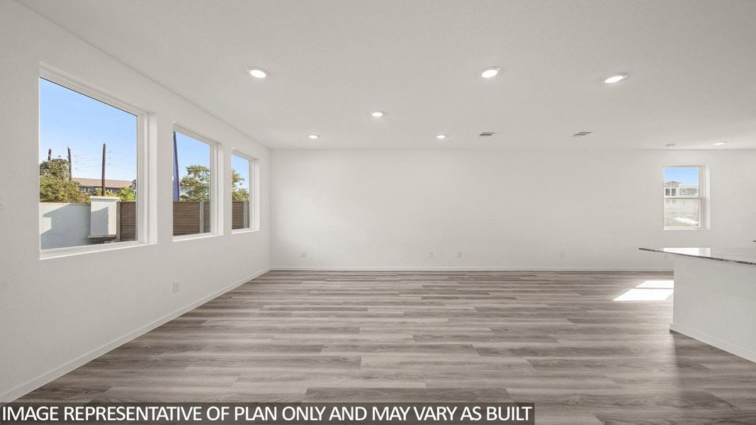 Spacious room with wood-finish flooring, recessed lighting, and multiple windows