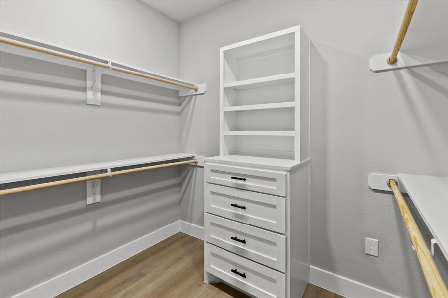 Large walk-in closet featuring built-in drawers and storage.