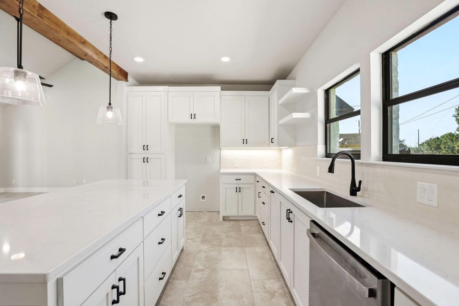 A well-lit culinary space offers sleek white cabinetry and generous counter surfaces. A well-lit culinary space offers sleek white cabinetry and generous counter surfaces.