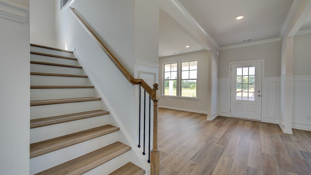 Stonefield foyer with open railing staircase and LVP flooring at Brighton in Locust Grove, GA.