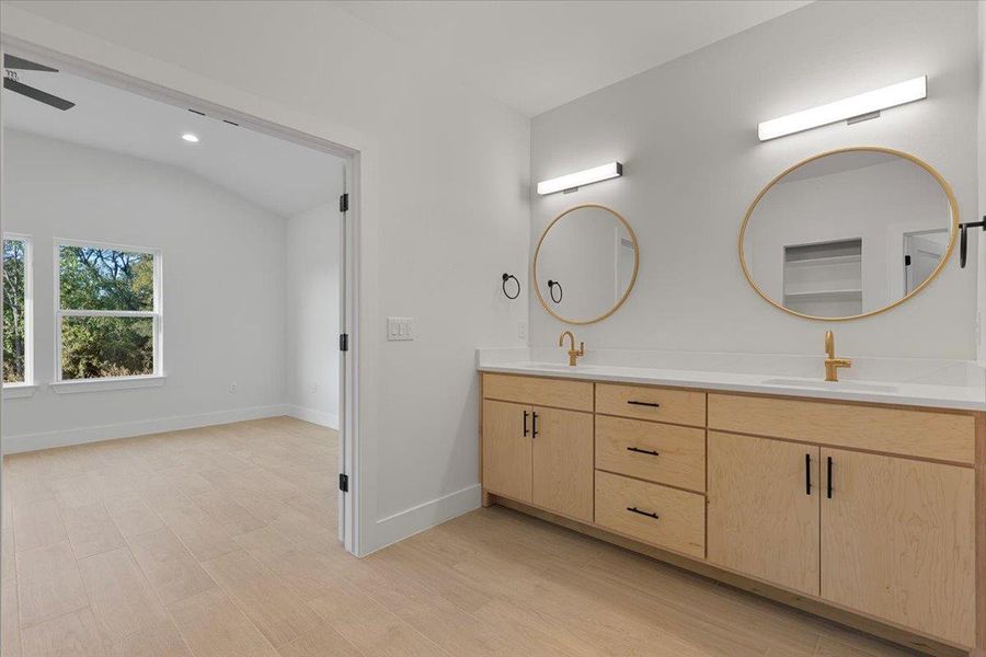 Full bath with double vanity, light wood-type flooring, lofted ceiling, and recessed lighting Full bath with double vanity, light wood-type flooring, lofted ceiling, and recessed lighting