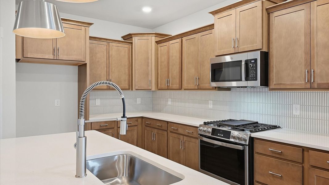 Notable kitchen space with elegant pendant lighting and a large island perfect for entertaining by DRB Homes