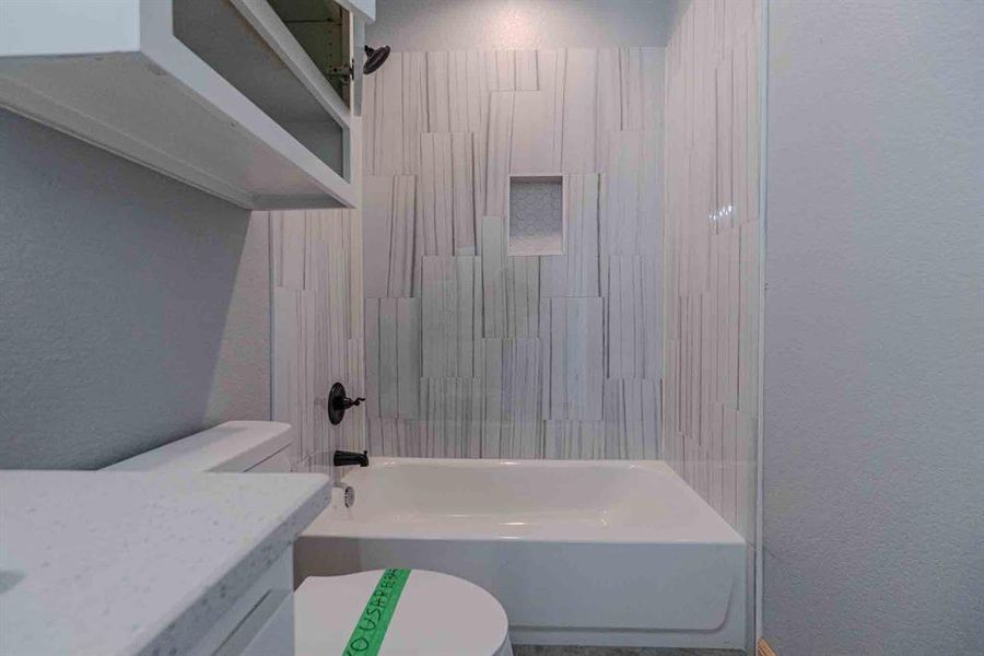 Bathroom with a textured wall, shower combination, and vanity Bathroom with a textured wall, shower combination, and vanity