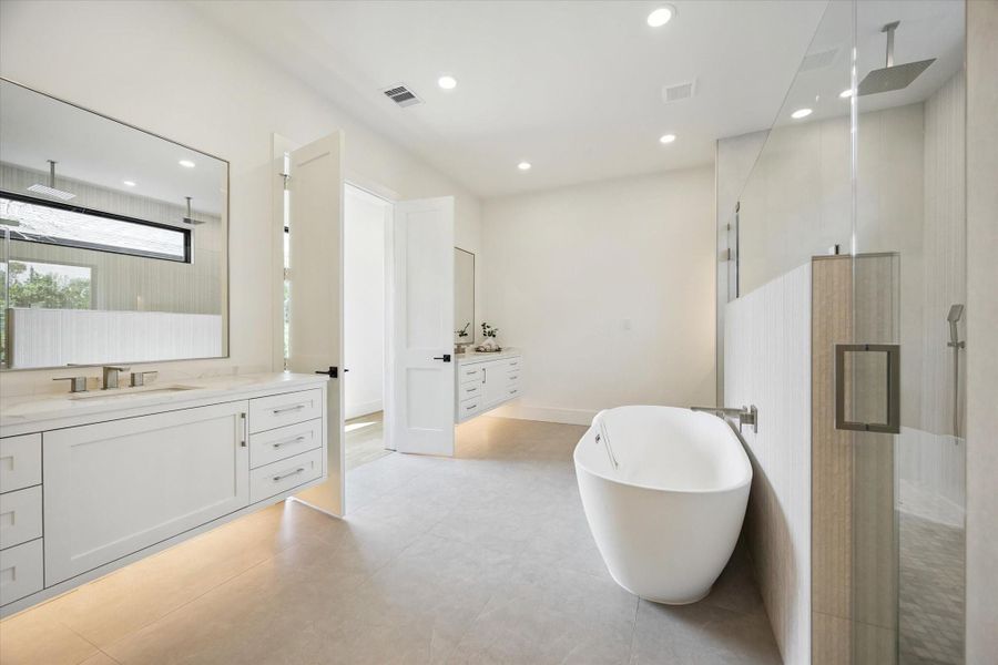 Spa-like primary bath with floating dual vanities and freestanding tub Spa-like primary bath with floating dual vanities and freestanding tub