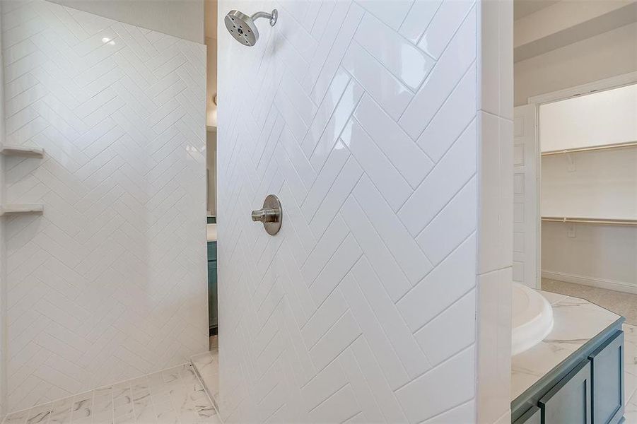 Bathroom featuring vanity and tiled shower