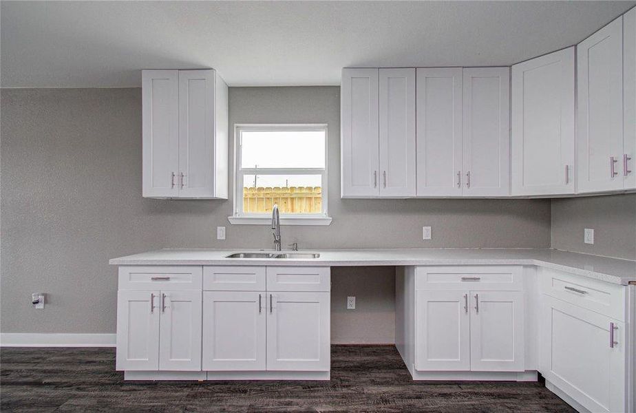 A closer look at the kitchen’s crisp white cabinetry, modern hardware, and ample workspace.