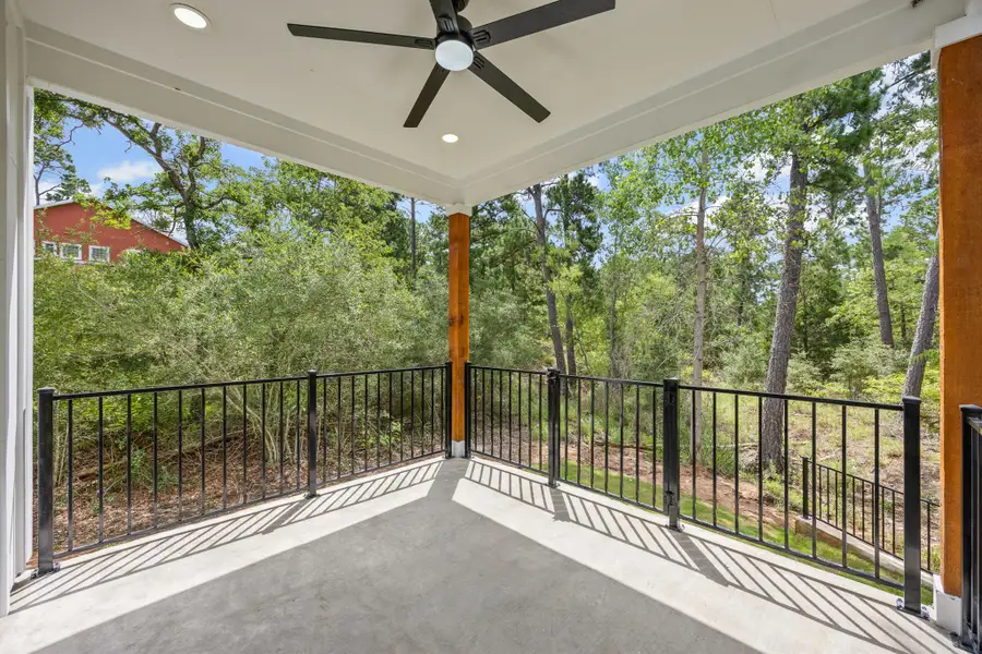 Balcony featuring a ceiling fan and view of wooded area Balcony featuring a ceiling fan and view of wooded area