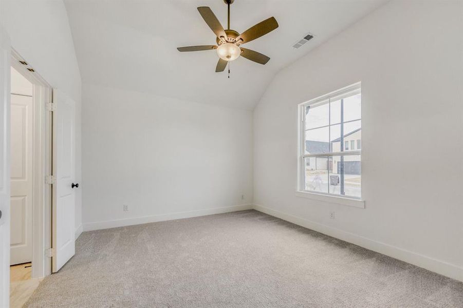 Unfurnished room with light colored carpet, a ceiling fan, and lofted ceiling Unfurnished room with light colored carpet, a ceiling fan, and lofted ceiling