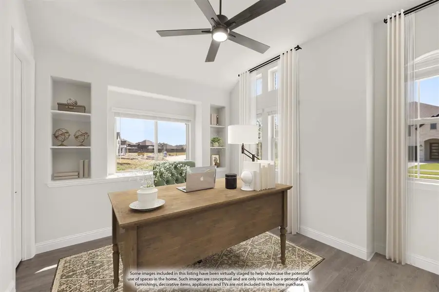 Home office with wood desk, built-in shelves, ceiling fan, and large windows with natural light Home office with wood desk, built-in shelves, ceiling fan, and large windows with natural light