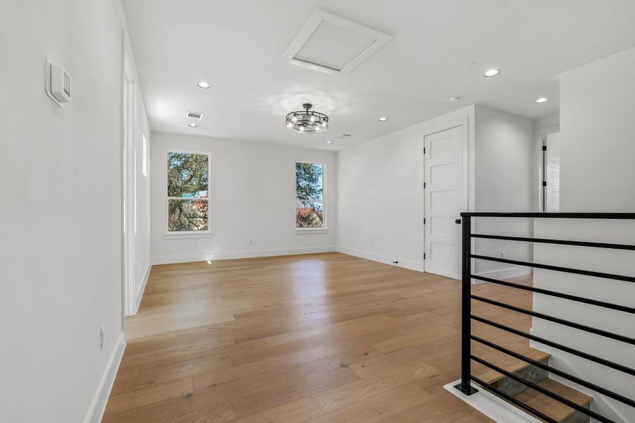 Unfurnished room with baseboards, visible vents, attic access, light wood-style flooring, and recessed lighting