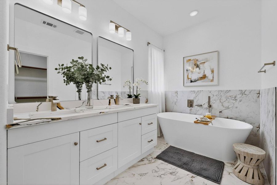Bathroom with double vanity, tile walls, a freestanding tub