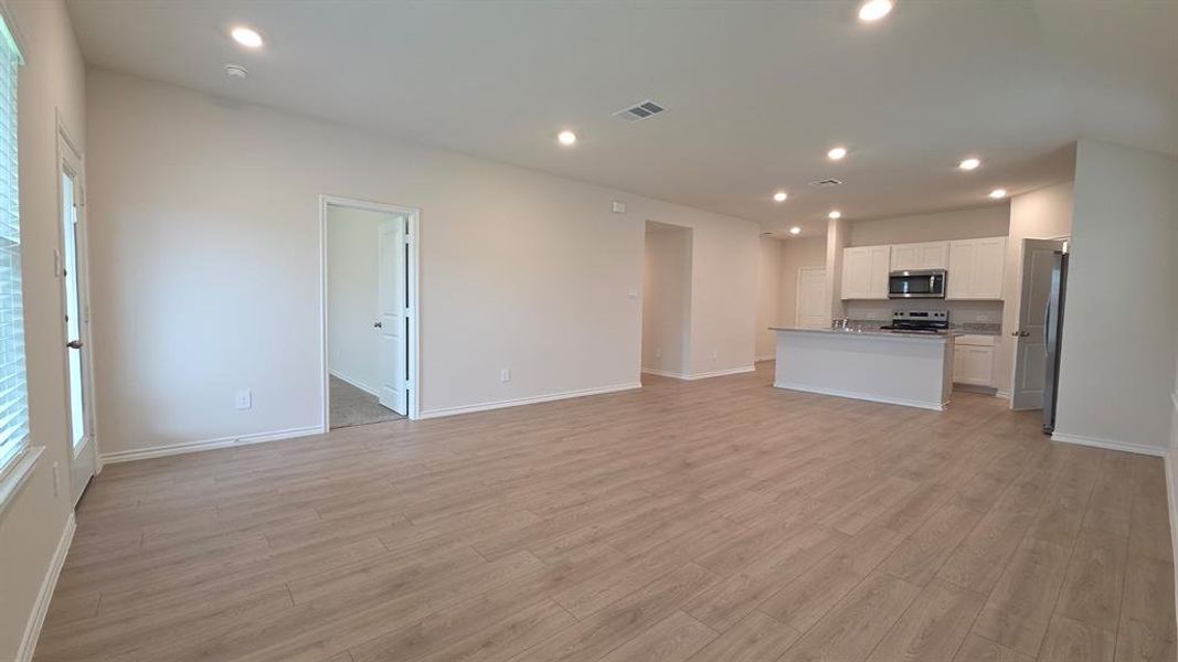 Open-concept interior featuring wood-finish flooring, recessed lighting, and light-toned walls
