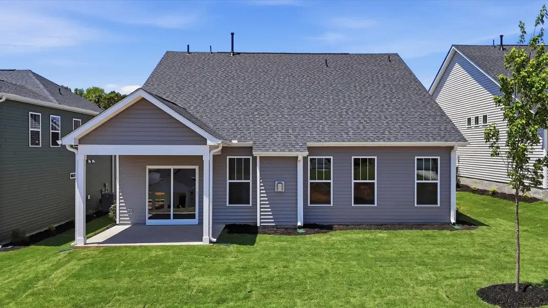 Vibrant rear outdoor space featuring a covered porch and exceptional craftsmanship located at Iris Meadows