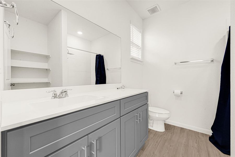 Modern and clean bathroom featuring a sleek vanity and updated flooring.