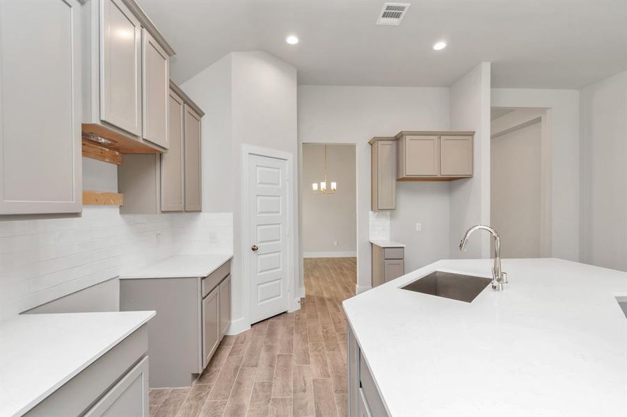 Culinary haven, featuring granite countertops, a tile backsplash, stainless steel appliances (to be installed), and 42” upper cabinets. Sample photo of completed home. Actual colors and selections may vary.