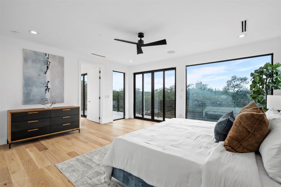 This bright room features wide plank hardwood flooring, recessed lighting, and a ceiling fan