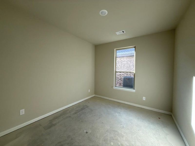 Unfurnished room featuring baseboards and unfinished concrete flooring