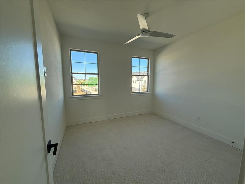 Spare room featuring ceiling fan and light carpet