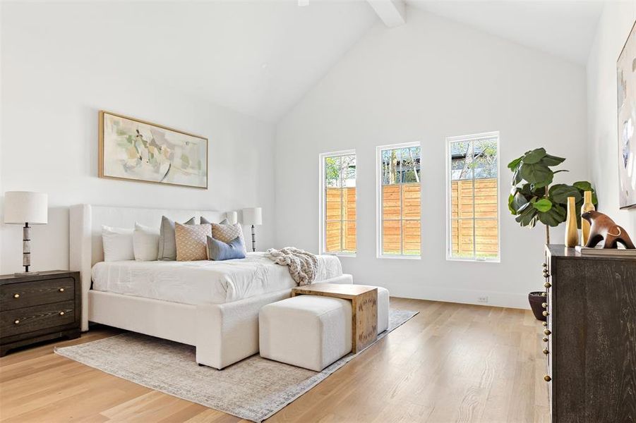 Bedroom featuring high vaulted ceiling, beamed ceiling, and light wood-type flooring Bedroom featuring high vaulted ceiling, beamed ceiling, and light wood-type flooring