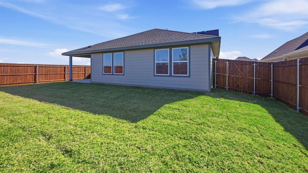 Rear view of property with a shingled roof and a fenced backyard Rear view of property with a shingled roof and a fenced backyard