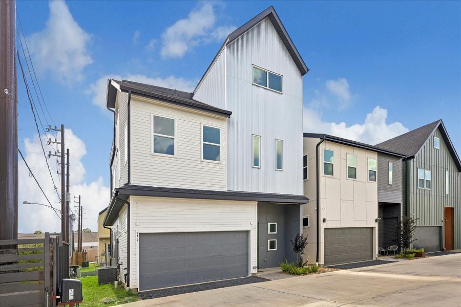 Angled front exterior highlighting the home's distinctive vertical façade, contemporary architectural design, and attached two car garage. Angled front exterior highlighting the home's distinctive vertical façade, contemporary architectural design, and attached two car garage.