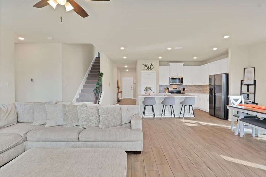 Living room featuring light hardwood / wood-style flooring, ceiling fan, and sink