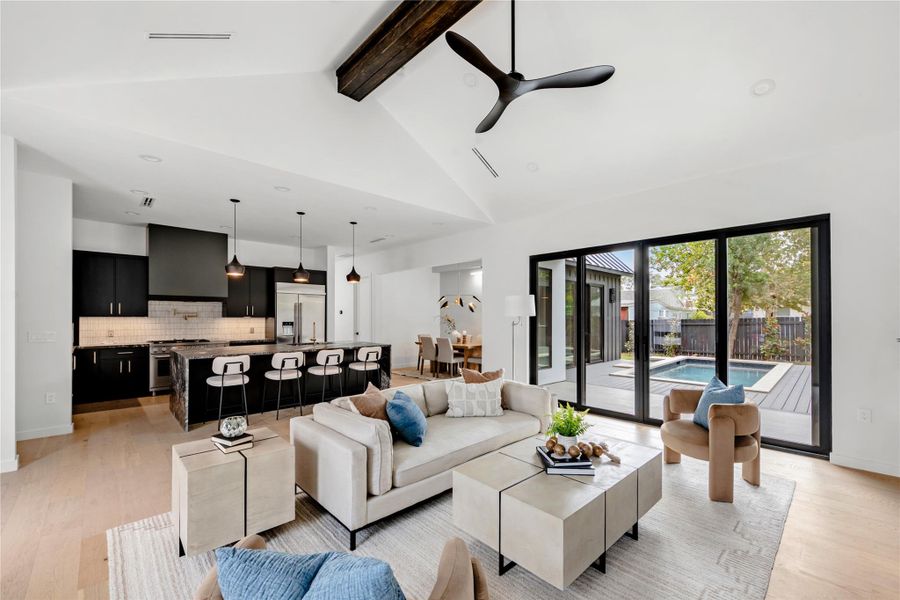 Living room with light wood-style flooring, beam ceiling, ceiling fan, high vaulted ceiling, and recessed lighting