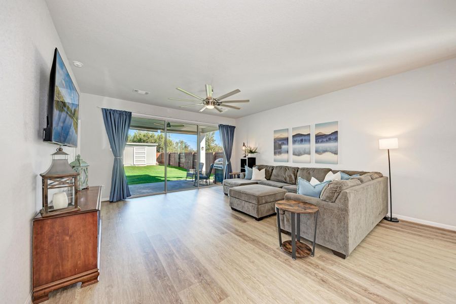 Living area featuring light wood finished floors and a ceiling fan