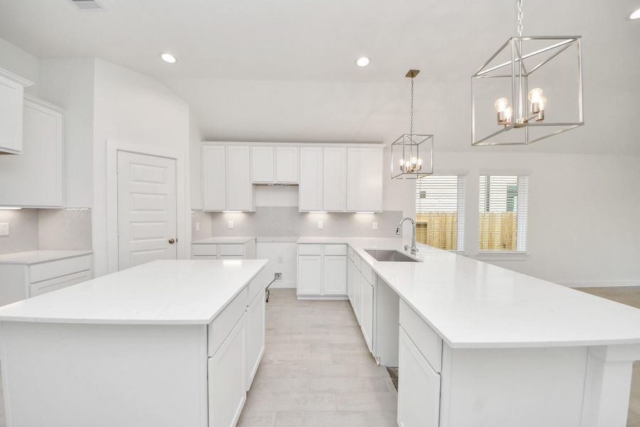 This kitchen is truly a chef's dream! This haven Boasts high ceilings, recessed & pendant lighting, stained wood cabinets, granite countertops, stainless steel appliances, a modern tile backsplash. All of this overlooks your expansive family room, creating a perfect space for culinary delights and family gatherings. Sample photo of completed home with similar floor plan. Actual colors and selections may vary. This kitchen is truly a chef's dream! This haven Boasts high ceilings, recessed & pendant lighting, stained wood cabinets, granite countertops, stainless steel appliances, a modern tile backsplash. All of this overlooks your expansive family room, creating a perfect space for culinary delights and family gatherings. Sample photo of completed home with similar floor plan. Actual colors and selections may vary.