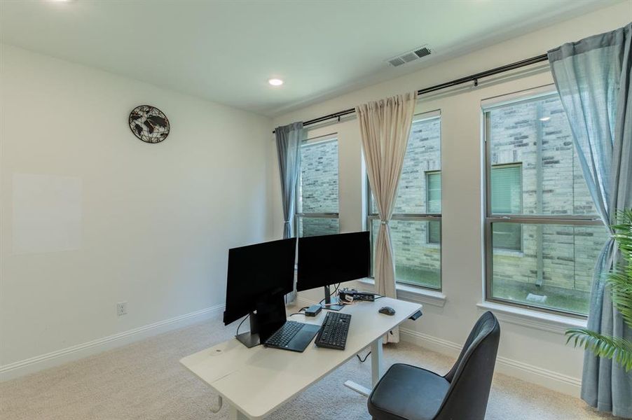 Room featuring multiple windows with dark curtain rods, light wall paint, and recessed ceiling lighting