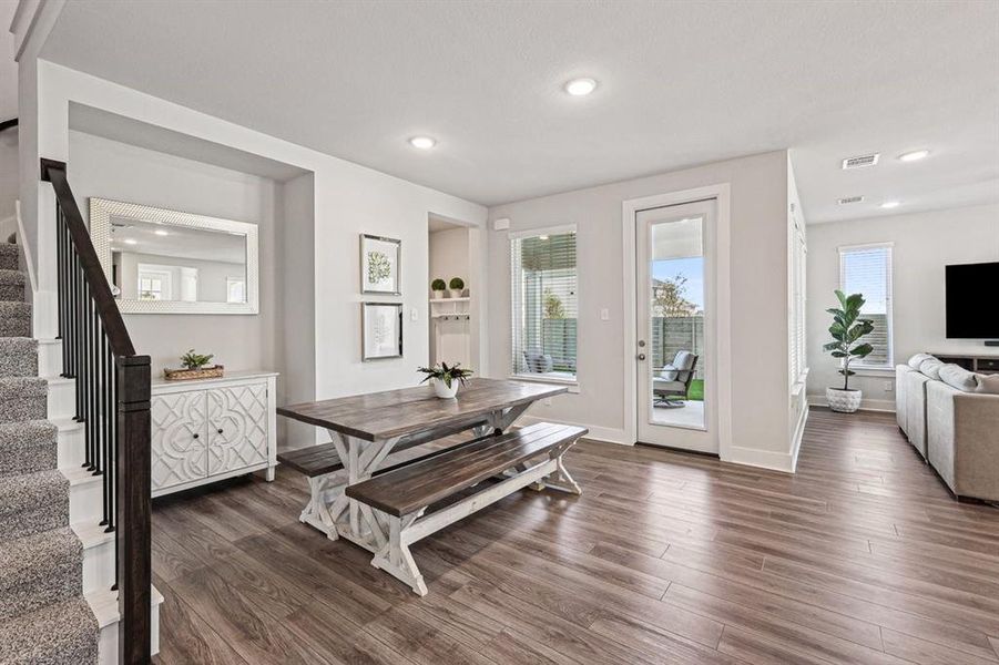 Dining area with a healthy amount of sunlight, open stair railing and LVP flooring