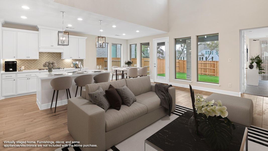 Living room featuring light wood-style floors, recessed lighting, and a high ceiling