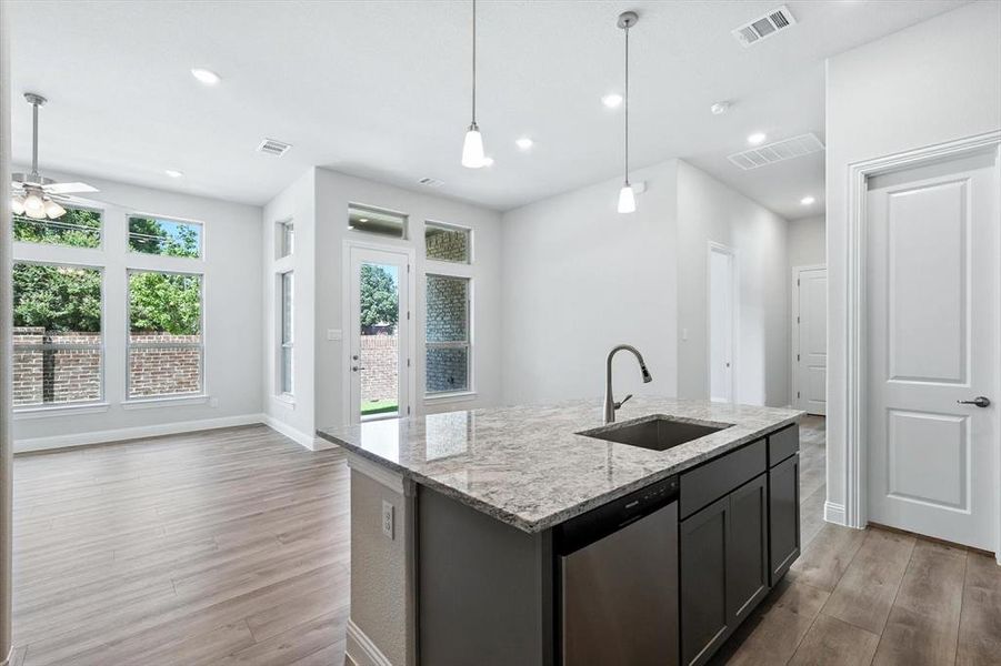 Kitchen with light wood-style flooring, dishwasher, open floor plan, a ceiling fan, and recessed lighting Kitchen with light wood-style flooring, dishwasher, open floor plan, a ceiling fan, and recessed lighting