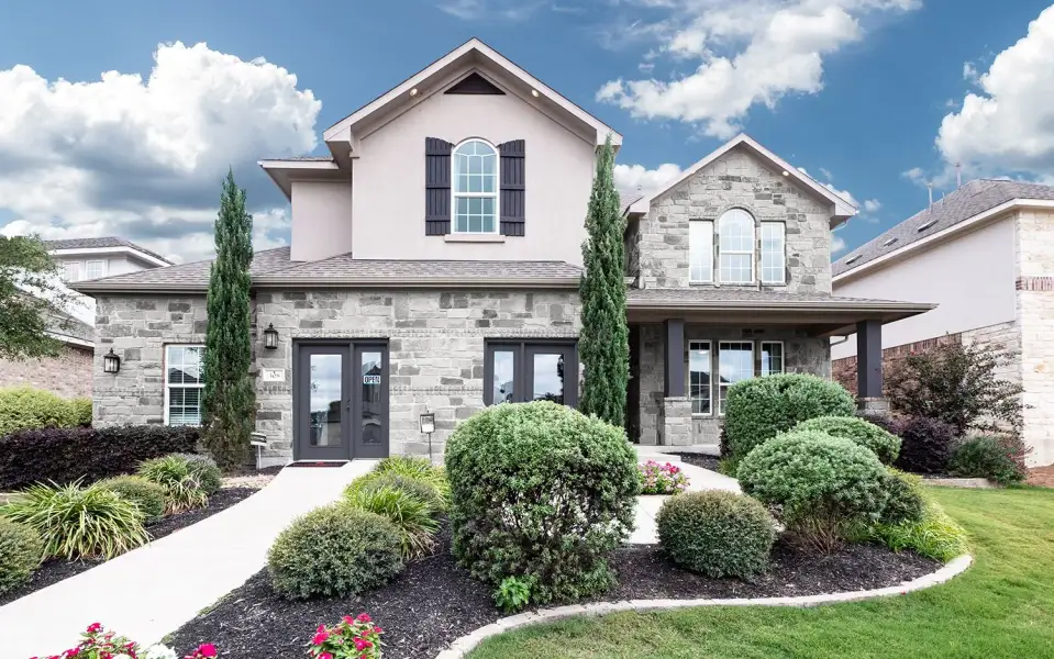 Front exterior of a new home in Sunfield, Buda, TX, highlighting curb appeal (Image 2). Front exterior of a new home in Sunfield, Buda, TX, highlighting curb appeal (Image 2).
