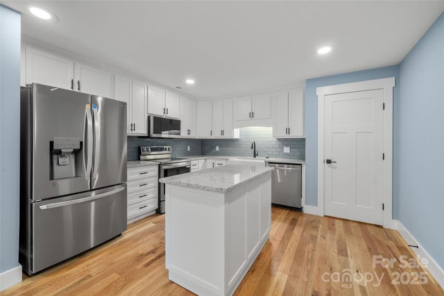 Lower level full kitchen with portable island on wheels to reposition or relocate as you wish! Huge pantry on right behind door