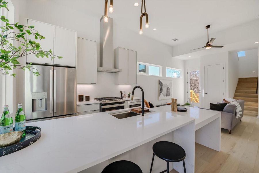 Kitchen with sink, a breakfast bar area, white cabinets, stainless steel appliances