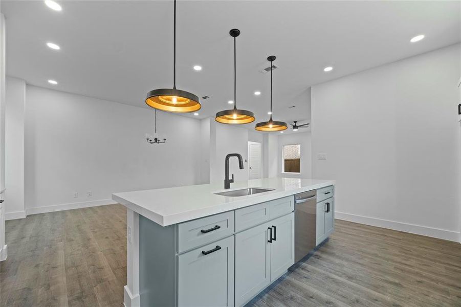 Kitchen featuring stainless steel dishwasher, recessed lighting, light countertops, and light wood-style flooring Kitchen featuring stainless steel dishwasher, recessed lighting, light countertops, and light wood-style flooring