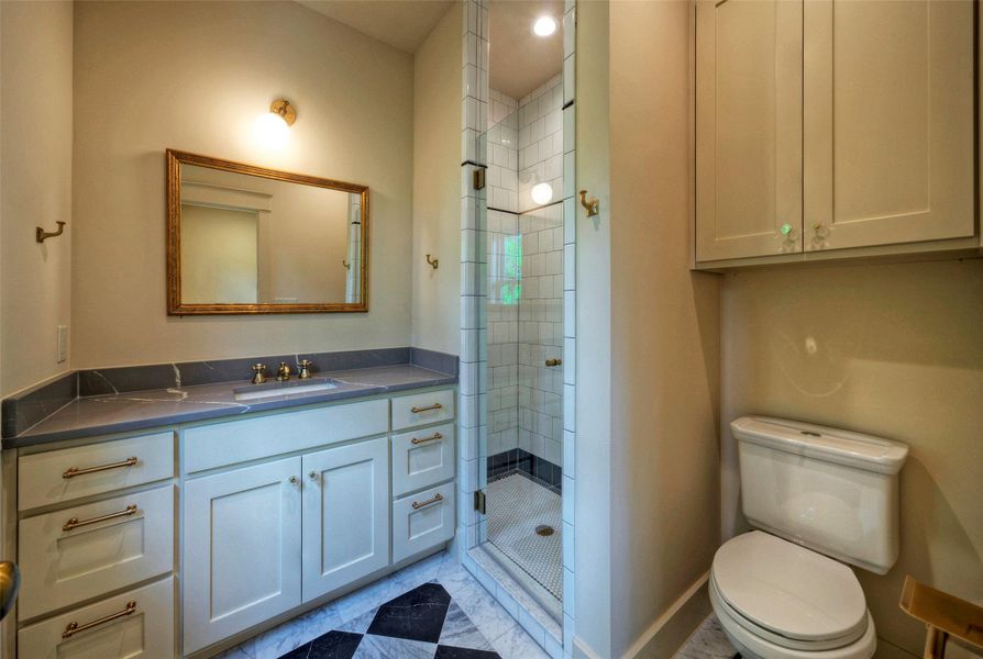 A well-appointed bath features a tiled walk-in shower and a modern vanity with elegant hardware.